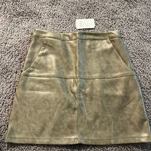 Olive green faux leather mini skirt. Zipper closure and 2 side pockets. NWT